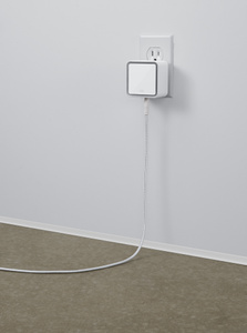 Angled view shows the compact water guard plugged into a wall socket and with its sensor cable hanging down and across the floor.