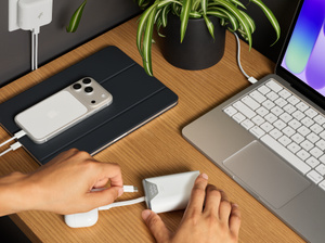 Nimble Wally Stretch-lichtnetadapter laadt links een iPhone op en rechts een AirPods-case