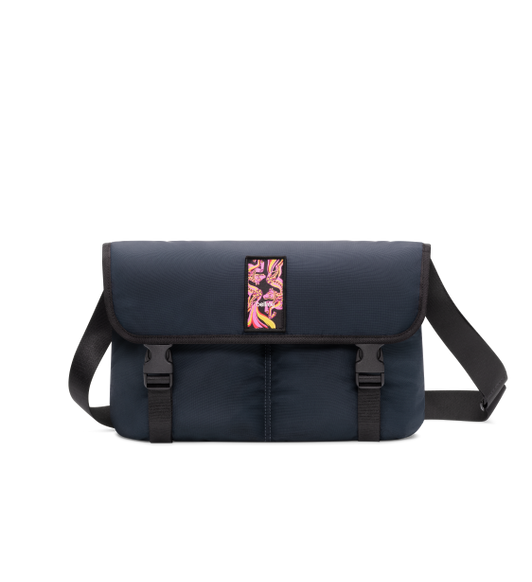 Bellroy Cinch Messenger bag, front exterior, blue color, shoulder strap behind bag, flap closed over front secured by two quick release buckles, colorful Year of the Horse graphic
