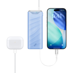 Nimble Champ Stretch 10K Charger at centre, front exterior, AirPods case charging on left, iPhone charging on right via retractable USB‑C cable