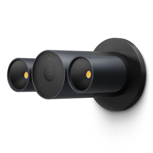 LG Floodlight Cam, graphite colour (dark grey), central cylindrical camera, two cylindrical floodlights connected on left and right of camera, angled straight. Short arm connects camera to circular wall mount in black colour