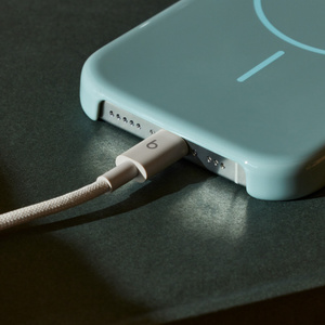 Gewebtes Beats USB-C auf USB-C Kabel in Energie-Grau, das mit einem Apple iPhone verbunden ist.