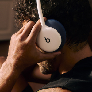 네이비 색상 Performance Knit 헤드밴드 쿠션 및 이어컵 쿠션이 장착된 클라우드 색상 Beats 360을 착용하고 운동 중인 사람