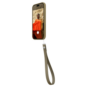 Laccetto da polso oliva (giallo-verde scuro) agganciato in basso a destra a una custodia in silicone per iPhone 18 Pro dello stesso colore mostrata di lato; la custodia copre l’iPhone su tutti i lati, tasto laterale in silicone in rilievo e tasto del Controllo fotocamera a filo, app Fotocamera sullo schermo, tasto del Controllo fotocamera attivo