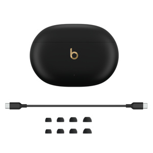 Fones de ouvido Beats Studio Buds+ e estojo de recarga em preto e dourado, com os fones dentro do estojo, um cabo para recarga de USB-C para USB-C e pontas de fone em quatro tamanhos 