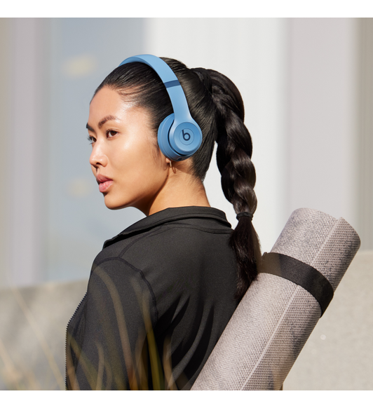 Personne portant un casque d’écoute Beats Solo 4 en bleu ardoise.