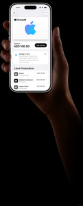 iPhone in hand, Wallet app active, Apple Account balance of AED 100, text reads: Ready to use, Pay with your iPhone in the Apple Store, shop online or buy apps, subscriptions and other services. Latest Transactions: Apple AED, Added to balance AED 250, Apple Store AED 550
