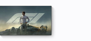 Quảng bá của Apple TV, tựa phim: F1 the Movie (tựa Việt: Công Thức 1), Brad Pitt mặc trang phục đua Công Thức 1, nhìn về một bên một cách đầy tự tin và điềm tĩnh, đứng trước một chiếc xe đua F1, phía sau là phông nền có khói bốc lên từ bánh xe và bầu trời màu xanh thẫm