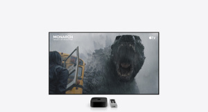 Apple TV 4K, black color, and Siri Remote, silver color, positioned below a large television display