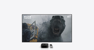 黑色 Apple TV 4K 與銀色 Apple TV Remote，擺放在大型電視顯示器下方