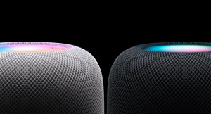 Side view of two HomePod speakers positioned side by side — the left speaker is White, the right speaker is Midnight