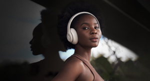 Zijaanzicht van de Beats Studio Pro Wireless-koptelefoon in zandsteen met het opvallende Beats-logo