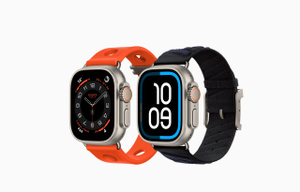 Apple Watch Hermès Ultra 3 devices: titanium cases, natural colour, edge-to-edge display, rounded corners, right side exterior, Digital Crown, microphone, raised side button, Maritime watch face (hour, minute, second hands), paired with Scub'H Diving band, orange néon colour (bright orange), Bleu Hydra digital watch face (time digits 10 09), paired with En Mer band, noir/bleu nuit colour (black with dark blue diagonal textured stripes)