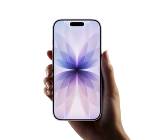 En hånd holder en iPhone med skjerm helt ut til kantene og Dynamic Island øverst; på skjermen vises en lilla blomsterlignende bakgrunn på hvit bakgrunn.
