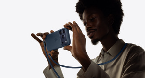 Iemand maakt een foto met een iPhone 17 Pro in een siliconenhoesje dat aan een Crossbodykoord is bevestigd