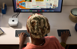 デスクに向かいApple製品を使って作業をしている1人のプロ。Studio Displayに接続されたMac miniがあり、プロの手はTouch ID搭載Apple Magic Keyboard（テンキー付き）とMagic Trackpadに置かれている