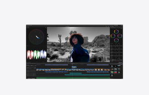 App Final Cut Pro, Timeline magn&eacute;tique pr&eacute;sent&eacute;e au bas d&rsquo;une vid&eacute;o d'une femme dans un d&eacute;sert en cours de montage, fond noir et blanc, personne en couleur, &eacute;diteur graphique Motion ouvert &agrave; gauche, inspecteur de couleur ouvert &agrave; droite