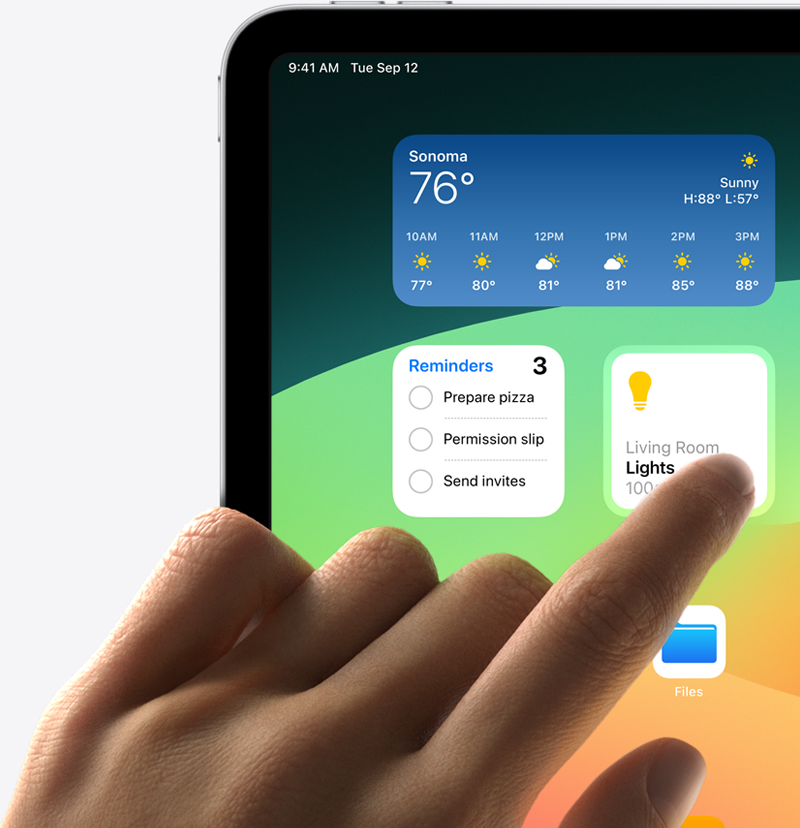 iPad, hand tapping widgets on screen