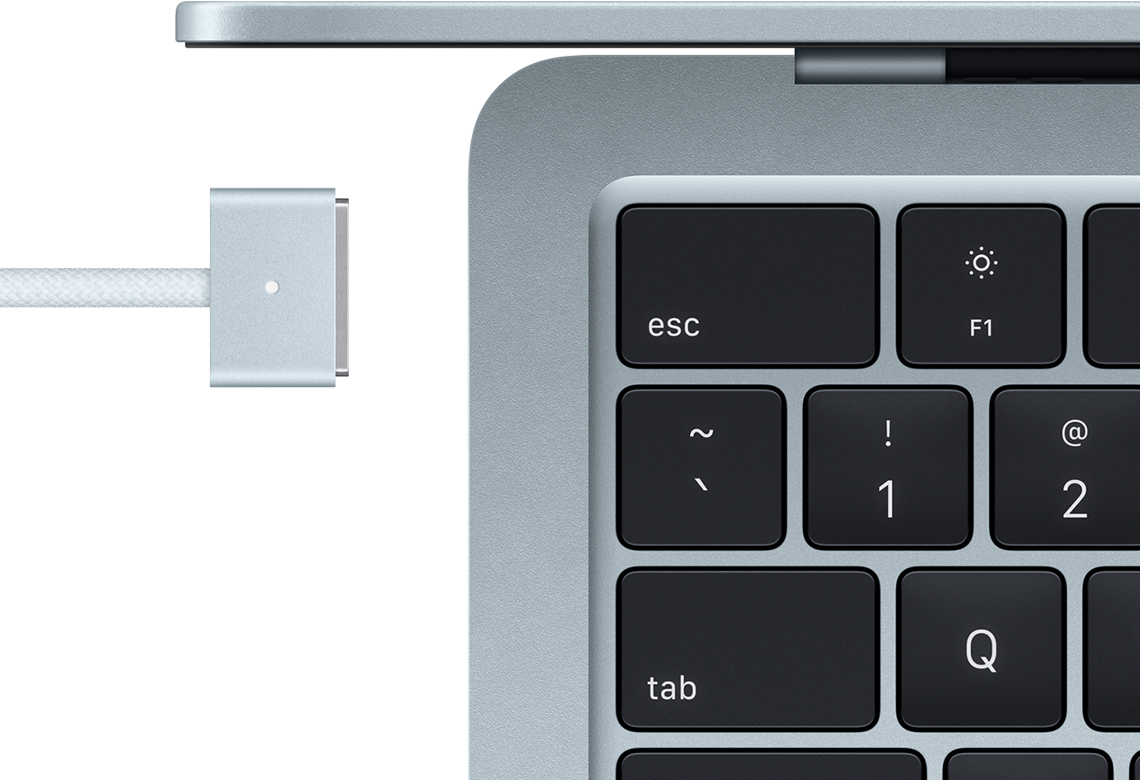 MacBook, top left corner of keyboard, MagSafe charging cable plugged in
