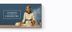 Title, Lessons in Chemistry, Brie Larson stands in front of a counter, on her right are ingredients for cooking, including eggs, pasta, and cheese, on her left are tools for chemistry experiments, including beakers, vials, and flasks, her dog looks up at her expectantly, its head peaking just above the counter.
